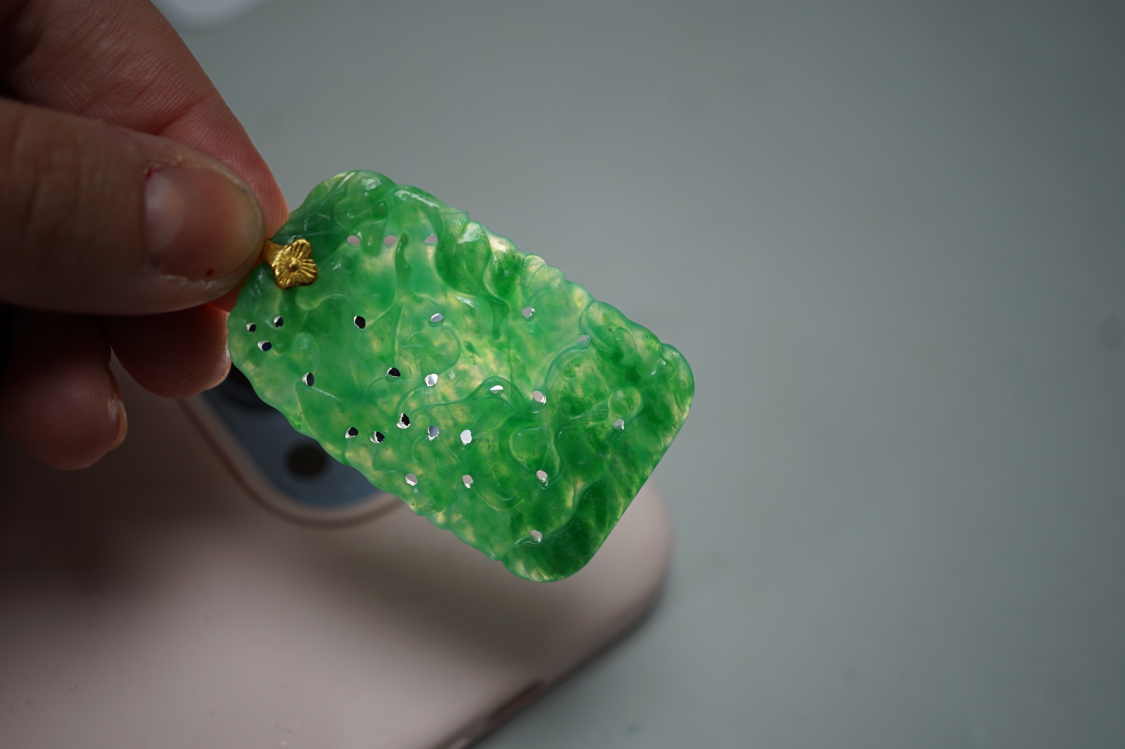 A carved Chinese jadeite pendant with pierced decoration. 5.5 x 3cm